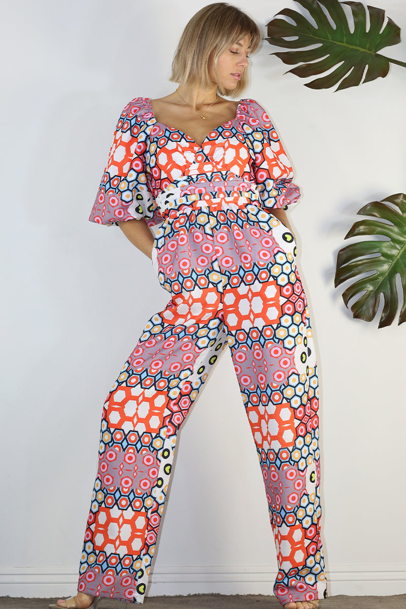 Weezie D. Playful Printed Jumpsuit in coral print. Our jumpsuit has an elastic sweetheart neckline. Wear to your captain's dinner on your upcoming cruise, bridal or baby showers, day parties or date.
