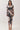 Front view of abstract print ruched V-neck midi dress with long sleeves, draped waist and front slit in neutral tones