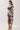 Side view of abstract print V-neck midi dress showing ruched draping, fitted waist and deep front slit