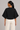 Back view of black dolman sleeve knit top with sculpted silhouette