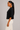 Side view of black dolman sleeve knit top with elbow length sleeves