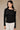 Black cutout long sleeve top with gold shoulder hardware front view