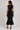 Black knit peplum top and fitted midi skirt set back view