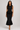 Black knit peplum top and fitted midi skirt set front view