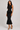 Black knit peplum top and fitted midi skirt set side view