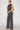 Side view of charcoal gray ruched wide leg pants set highlighting the gathered waist and asymmetrical overlay design