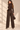 Back view of chocolate brown wide barrel leg knit pants featuring elastic waistband and structured seam detailing
