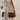 Close-up of oversized fabric-covered buttons on cream knit top
