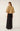 Back view of gold sequin tweed jacket showing textured metallic fabric, wide puff sleeves and shaped hem