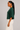 Side view of hunter green dolman sleeve knit top with elbow length sleeves