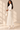 Side view of ivory faux leather and pleated chiffon midi skirt showing its structured upper panel and flowing hem