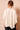Back view of ivory satin braided neck cape blouse featuring a flowing cape overlay and gathered neckline