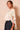Side view of ivory satin braided neck cape blouse showing the lightweight draped fabric and cascading cape silhouette