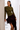 Model wearing an olive green ruched mesh long sleeve top with draped front