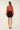 Back view of rust chiffon blouse featuring scattered tonal pearl embellishments, gathered shoulders and long balloon sleeves