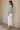 Side view of sage medium weight knit sweater with bell sleeves