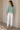 Back view of sage open knit sweater with scalloped hem