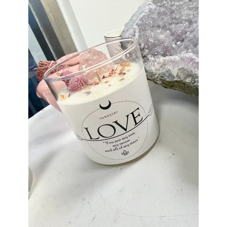 Weezie D. Love Rose Quartz Crystal Soy Candle in 11 ounce glass jar is scented with Vesta, a magical mixture of berries, lemon, fresh woody pine, eucalyptus, cedar leaf evergreens & a hint of juniper. Refreshing aroma to fill any room. Rose quartz crystal & dried rose flowers for a sweet topper. 