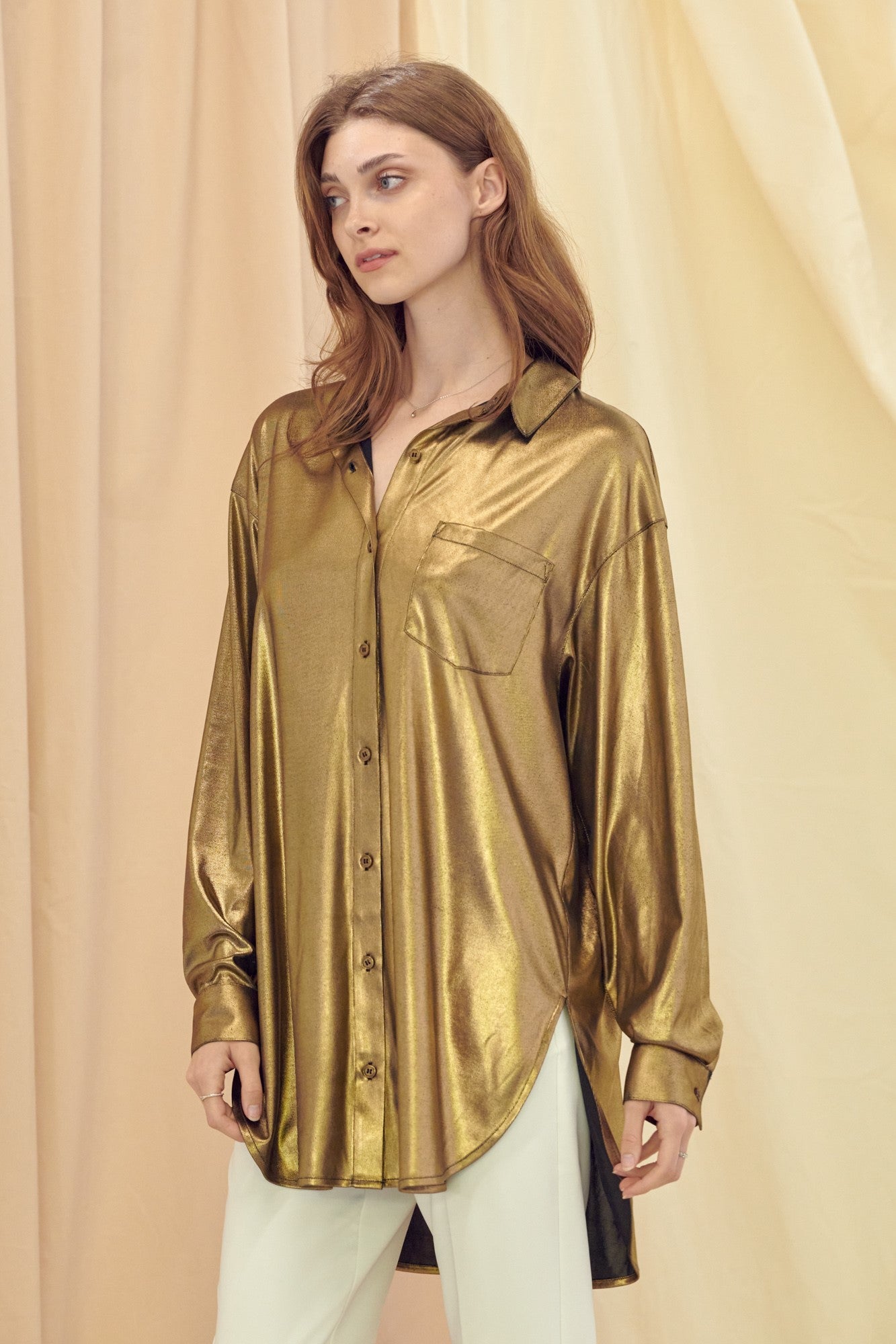 Weezie D. long sleeve Gold Metallic Button Up Stretch Top with front pocket is chic. Wear with denim, pants or even a skirt. We love the stretch metallic fabric for a flowy silhouette. Tuck blouse in or out for a relaxed look. Feels like luxury on your skin. Wear any time of year. Thigh Length 95% Polyester 5% Spandex