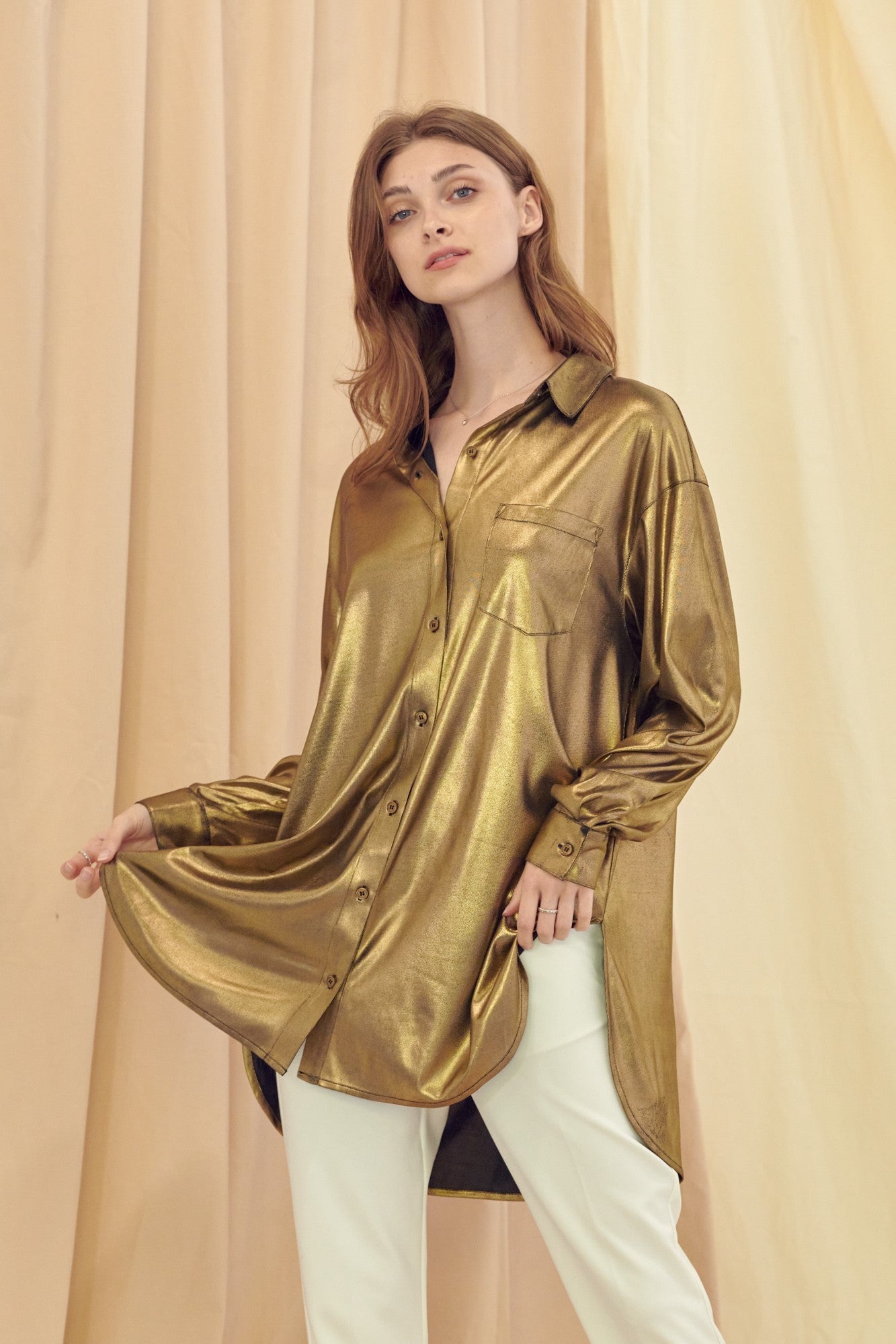Weezie D. long sleeve Gold Metallic Button Up Stretch Top with front pocket is chic. Wear with denim, pants or even a skirt. We love the stretch metallic fabric for a flowy silhouette. Tuck blouse in or out for a relaxed look. Feels like luxury on your skin. Wear any time of year. Thigh Length 95% Polyester 5% Spandex