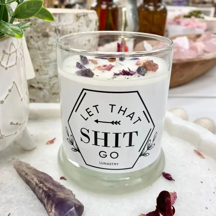 Weezie D. Amethyst Crystal Let That Shit Go Soy Candle is 11 ounces of freshly sweet & celestial aroma in a glass jar. A luxurious & elegant scent. We love the topped details of real amethyst crystals, dried rose petals & glitter stars.   